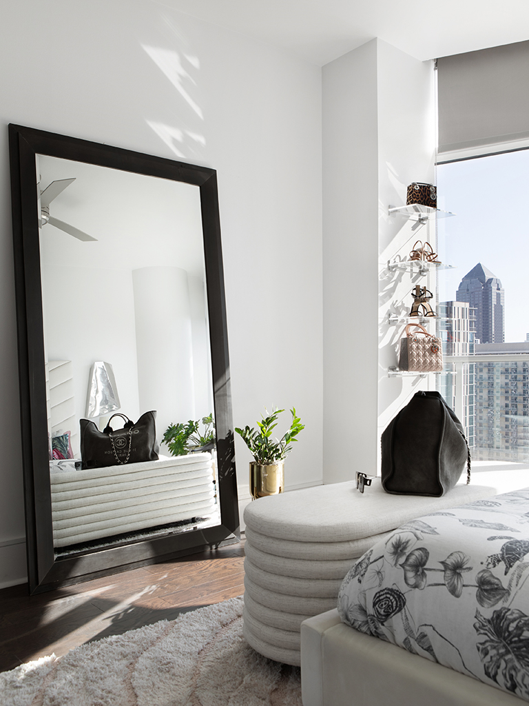 Modern bedroom accessorized with full length mirror and retail shelves.