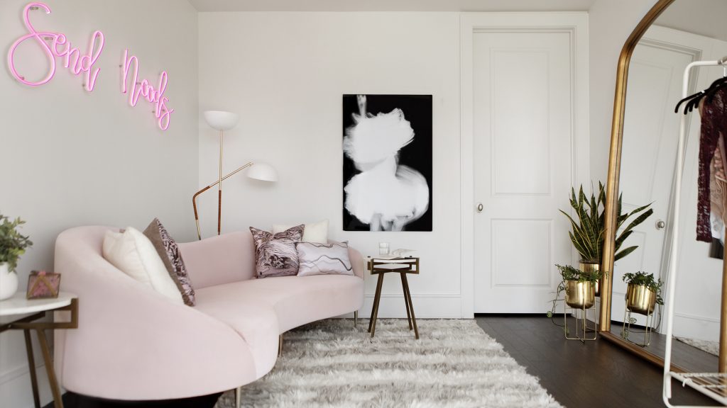 Modern designed office with blush sofa and playful art.