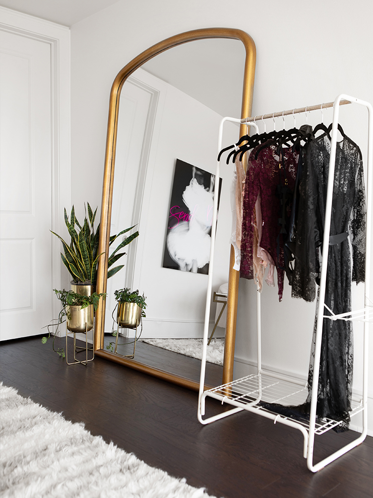 Modern dressing area with full length mirror and metal wardrobe.